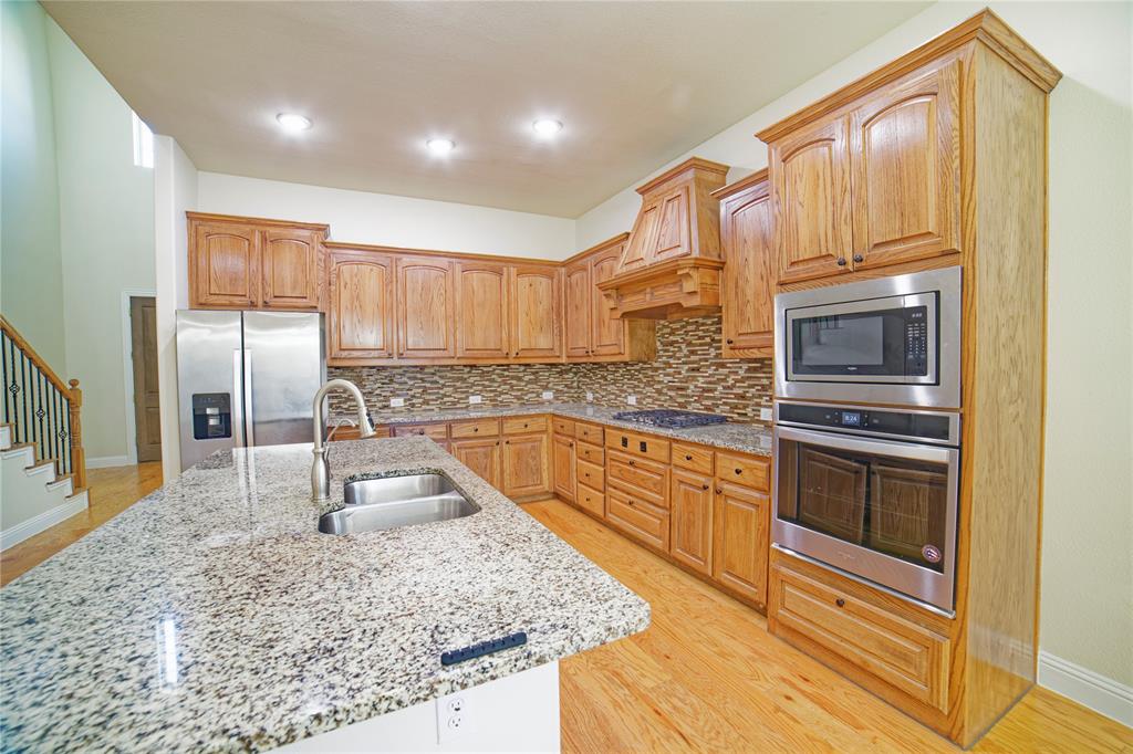 10929 Calvert Place McKinney, TX 75071 - Photo 16 of 39 a kitchen with stainless steel appliances granite countertop a sink stove and refrigerator