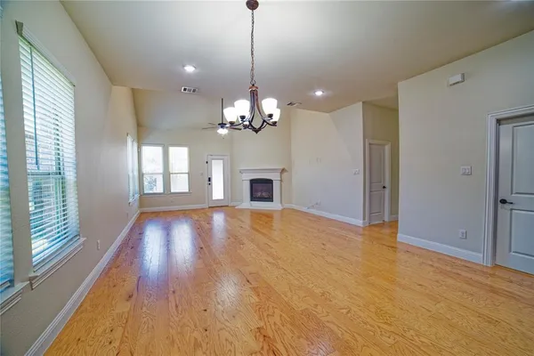 a view of a room with chandelier fireplace and wooden floor