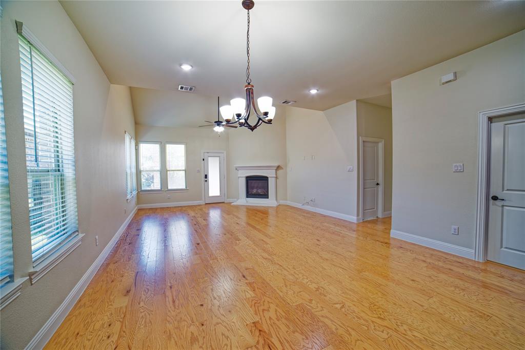 10929 Calvert Place McKinney, TX 75071 - Photo 18 of 39 a view of a room with chandelier fireplace and wooden floor