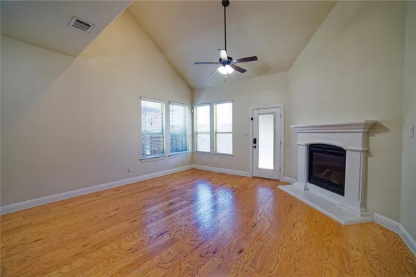 a view of empty room with wooden floor and fireplace