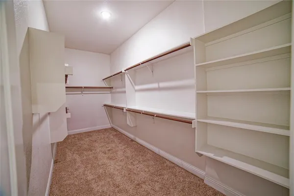 a view of walk in closet with empty racks