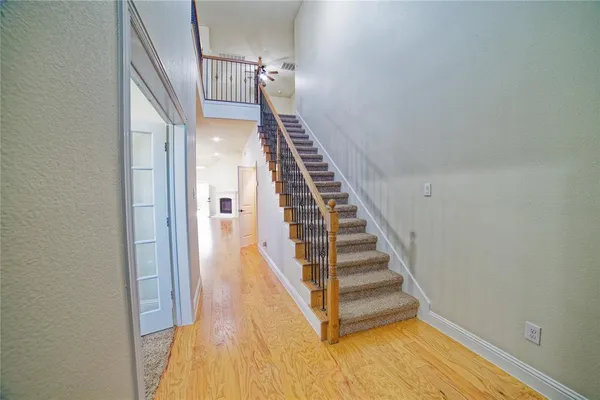 a view of a hallway with wooden floor and entryway