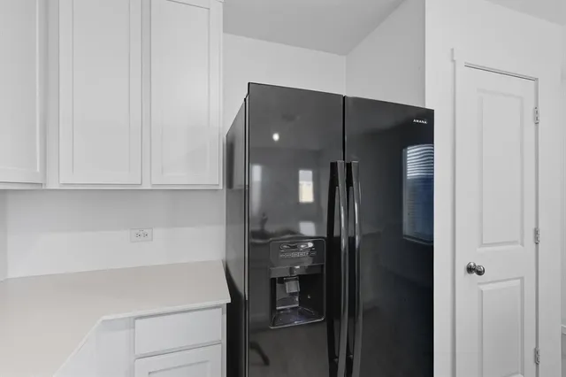 a kitchen with a refrigerator and cabinets