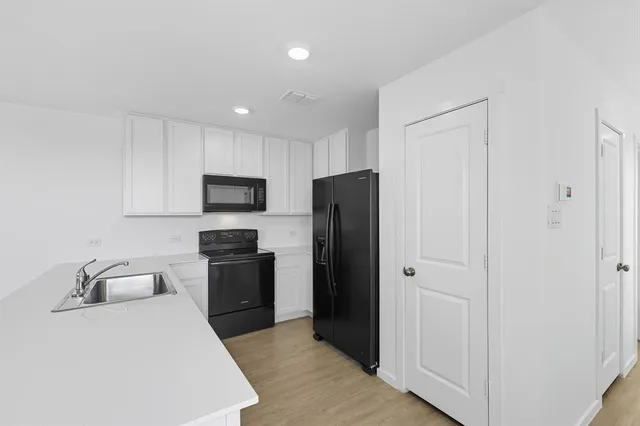 a kitchen with stainless steel appliances granite countertop a refrigerator and a sink