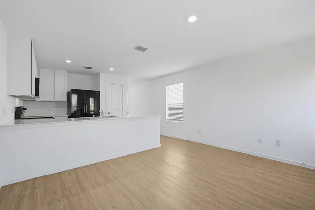 a view of kitchen with stainless steel appliances granite countertop a stove top oven a sink and dishwasher with wooden floor