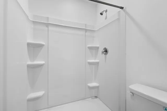 a bathroom with a toilet and a shower