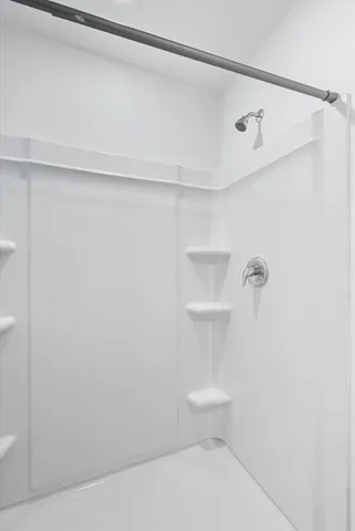 a bathroom with a white toilet and a shower