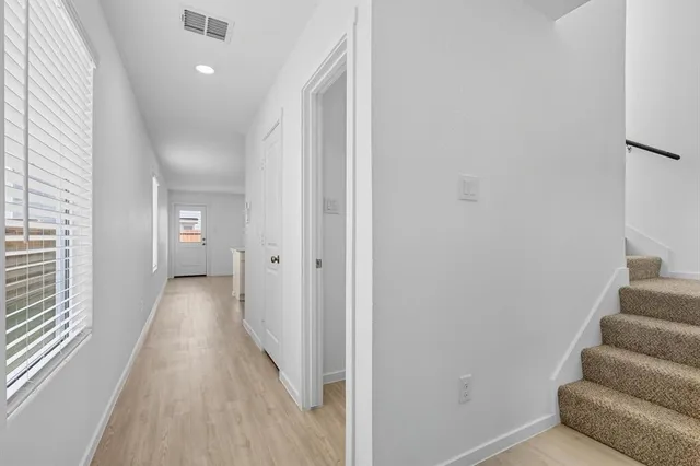 a view of a hallway with wooden floor and staircase