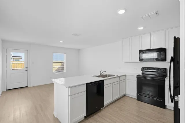 a kitchen with stainless steel appliances a stove a sink and a refrigerator
