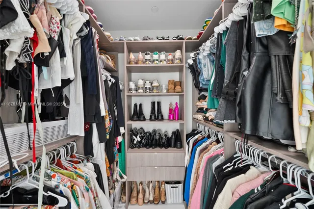 a view of walk in closet with clothes