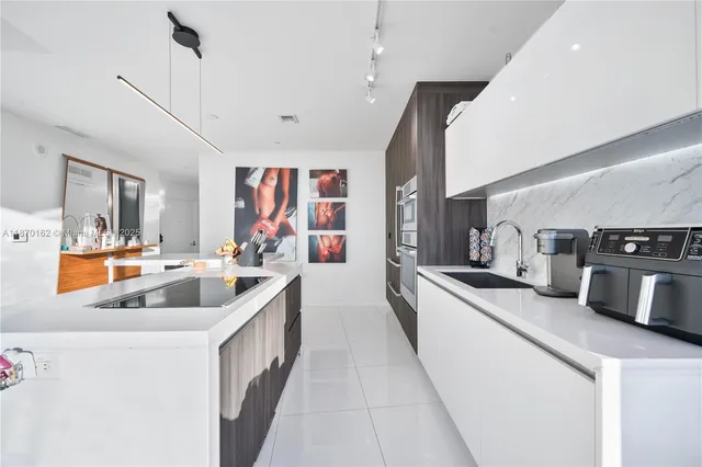 a kitchen with stainless steel appliances granite countertop a sink and a refrigerator