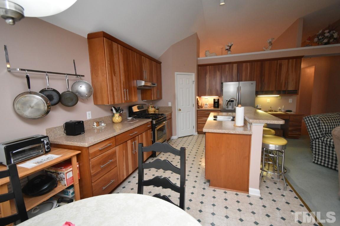 9904 Wyngate Ridge Drive Raleigh, NC 27617 - Photo 11 of 39 a kitchen with stainless steel appliances a stove a sink and a cabinets