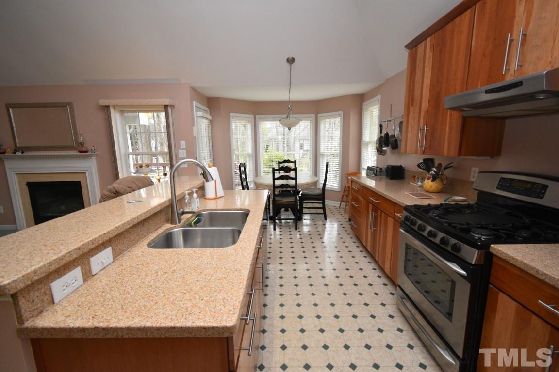 9904 Wyngate Ridge Drive Raleigh, NC 27617 - Photo 12 of 39 a kitchen with granite countertop a stove a sink and a refrigerator