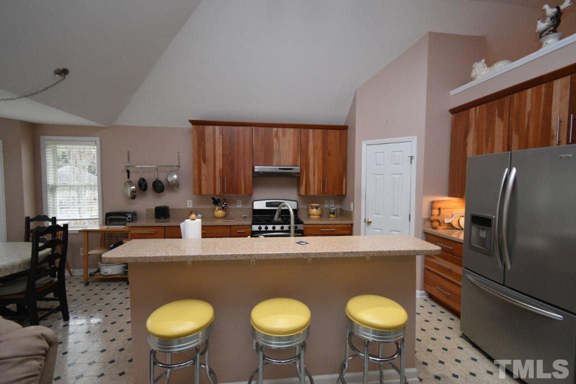 9904 Wyngate Ridge Drive Raleigh, NC 27617 - Photo 14 of 39 a kitchen with stainless steel appliances granite countertop a sink a stove a kitchen island and chairs
