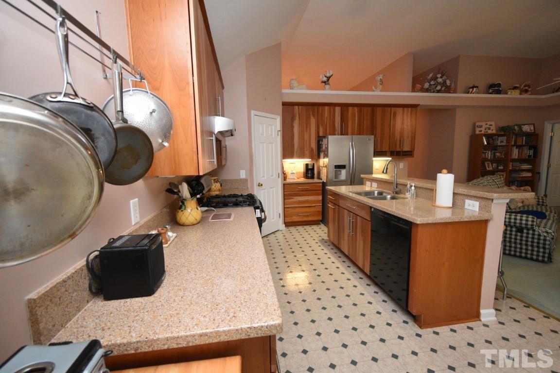 9904 Wyngate Ridge Drive Raleigh, NC 27617 - Photo 17 of 39 a kitchen with granite countertop a sink a stove and wooden cabinets