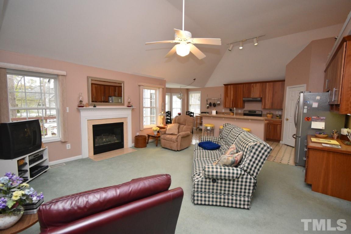 9904 Wyngate Ridge Drive Raleigh, NC 27617 - Photo 22 of 39 a living room with furniture a fireplace and a flat screen tv