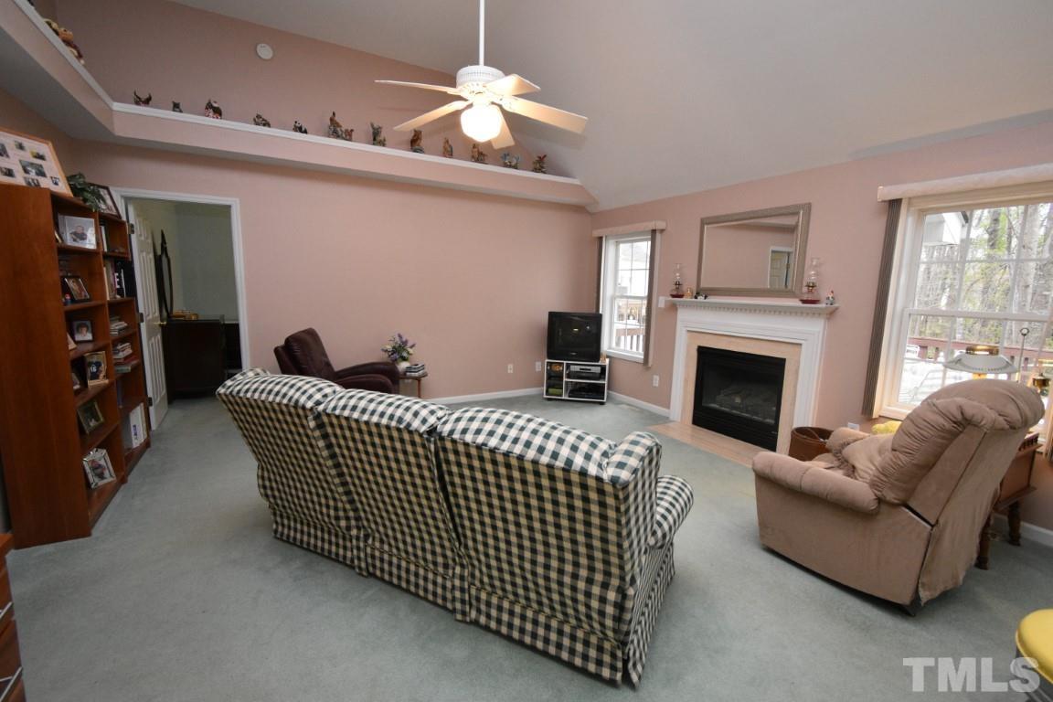 9904 Wyngate Ridge Drive Raleigh, NC 27617 - Photo 24 of 39 a living room with furniture a fireplace and a chandelier