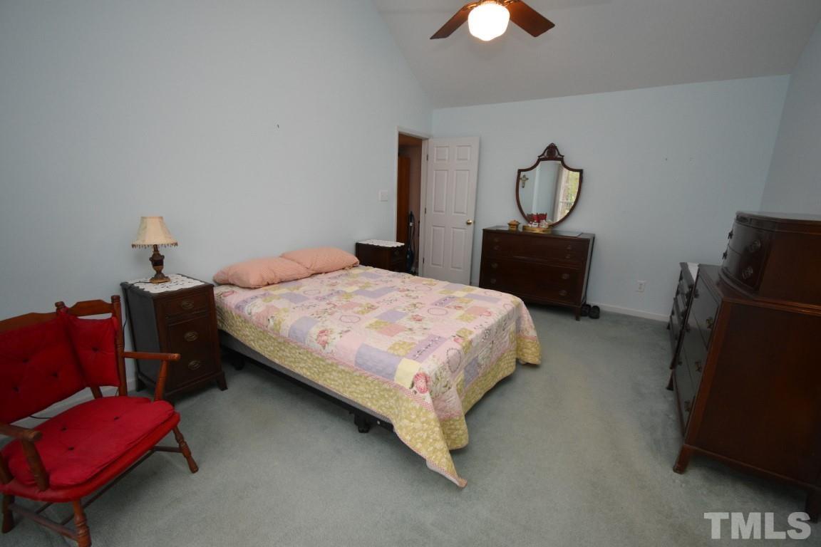 9904 Wyngate Ridge Drive Raleigh, NC 27617 - Photo 26 of 39 a bedroom with bed and a chandelier