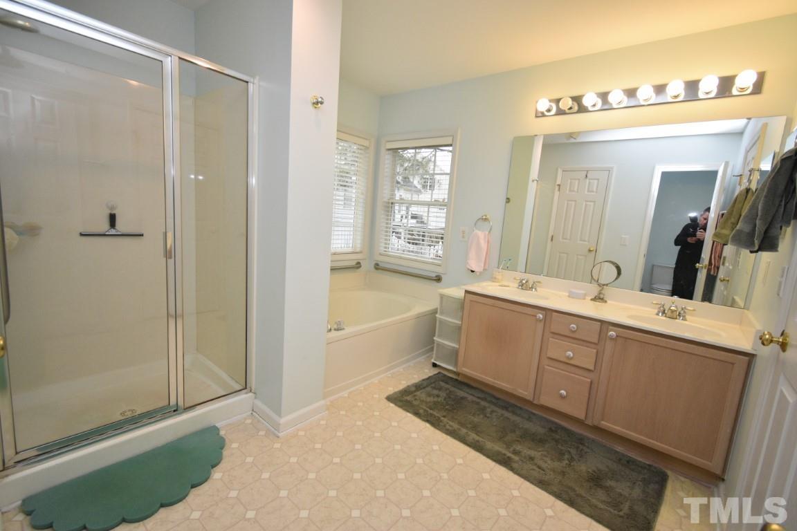 9904 Wyngate Ridge Drive Raleigh, NC 27617 - Photo 29 of 39 a large bathroom with a double vanity sink a large mirror and shower
