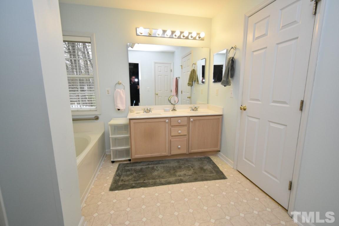 9904 Wyngate Ridge Drive Raleigh, NC 27617 - Photo 30 of 39 a bathroom with a sink a vanity and a mirror