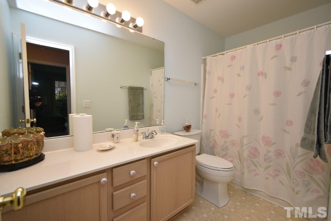 9904 Wyngate Ridge Drive Raleigh, NC 27617 - Photo 33 of 39 a bathroom with a sink a toilet and shower curtain