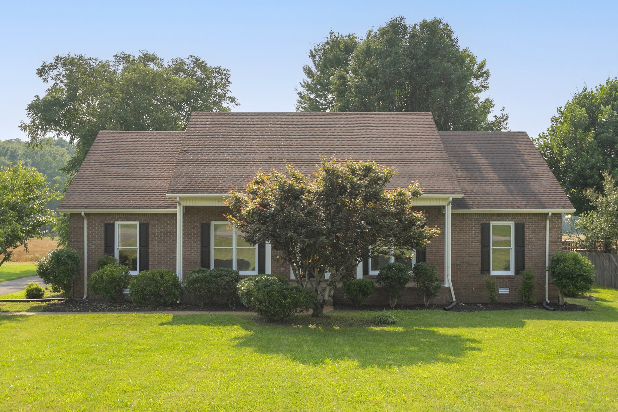 a front view of a house with a garden and yard
