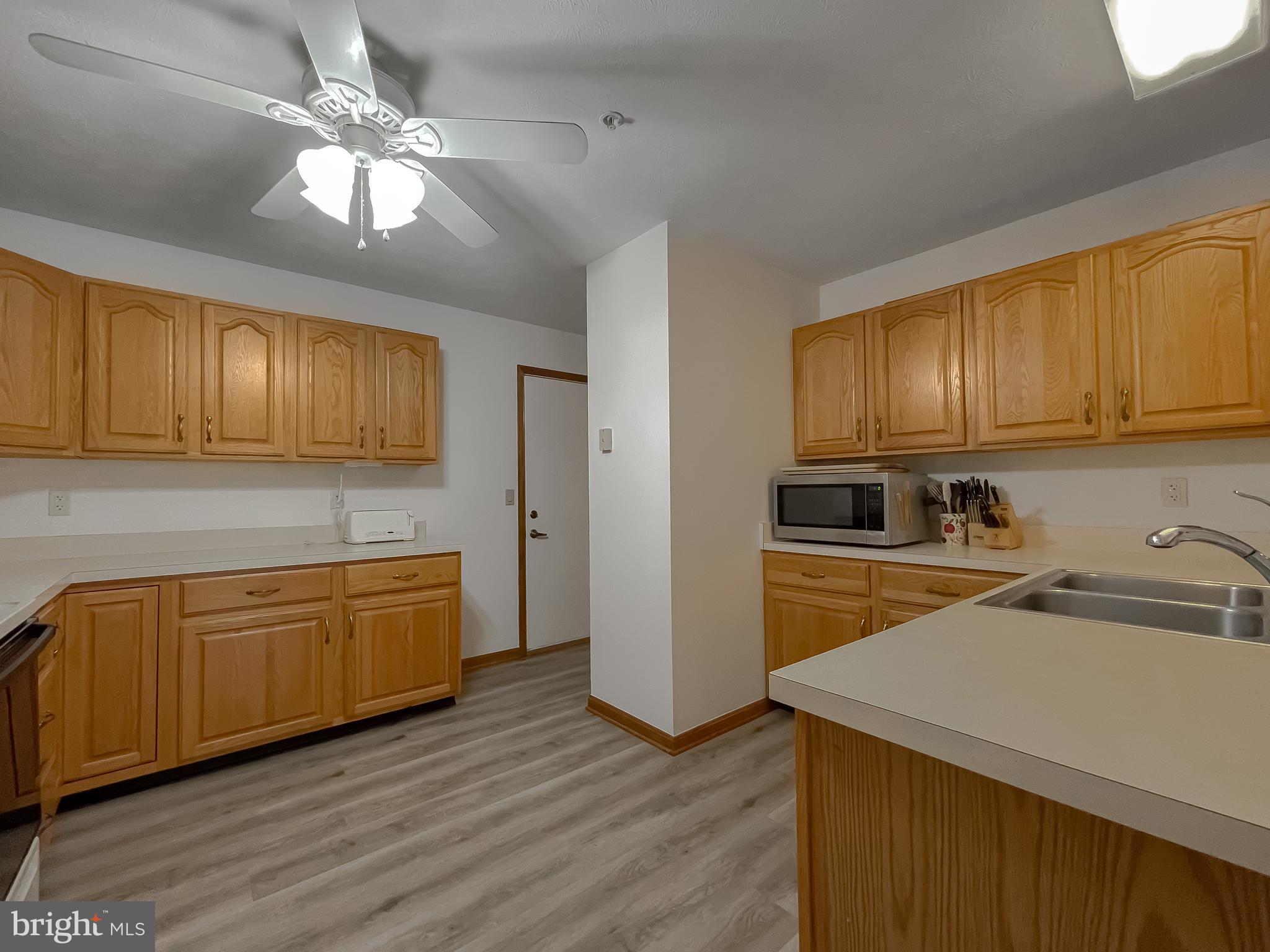 44059 Fieldstone Way California, MD 20619 - Photo 22 of 42 a kitchen with stainless steel appliances granite countertop wooden cabinets a stove top oven a sink and dishwasher with wooden floor
