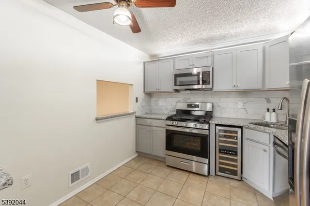 a kitchen with granite countertop a stove top oven microwave and cabinets