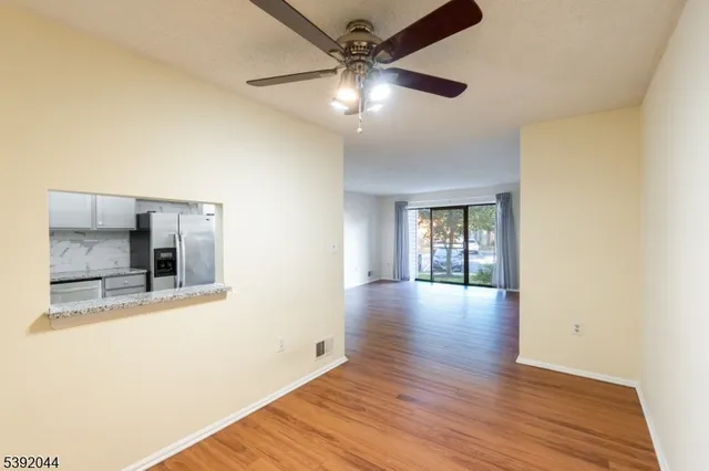 a view of a livingroom with wooden floor and a ceiling fan