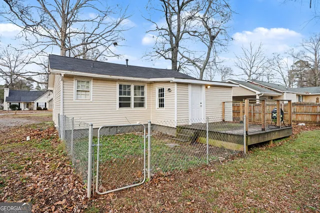 a view of a house with a yard and wooden fence