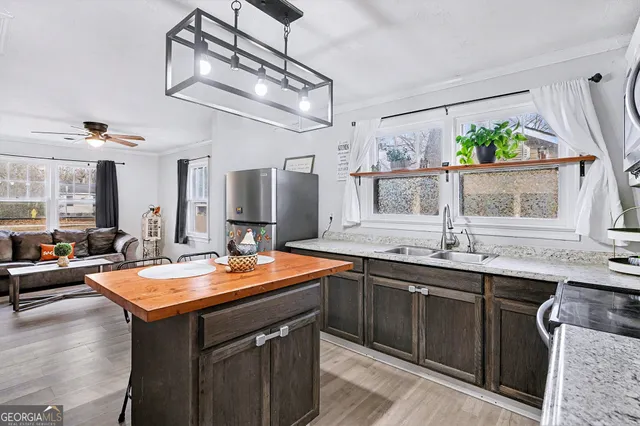 a room with stainless steel appliances granite countertop a sink and dishwasher with wooden floor