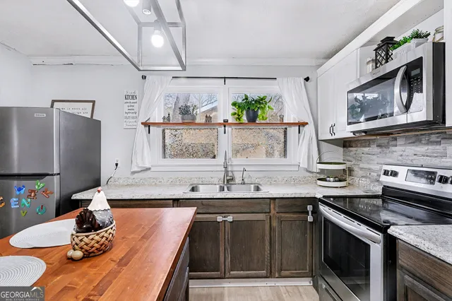 a kitchen with stainless steel appliances granite countertop a sink and cabinets