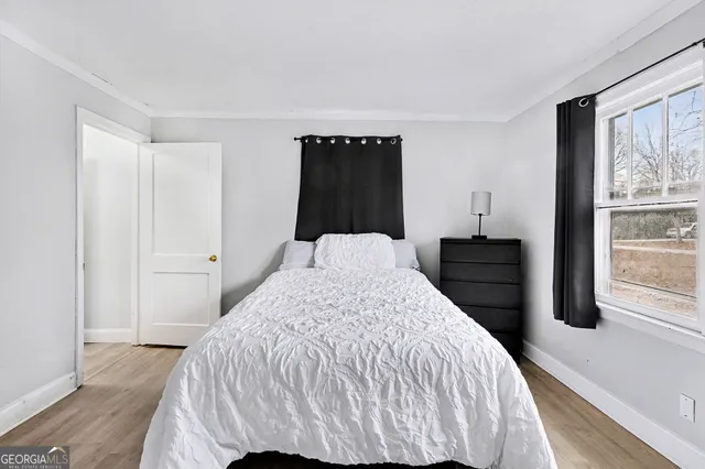 a bed sitting in a bedroom and wooden floor
