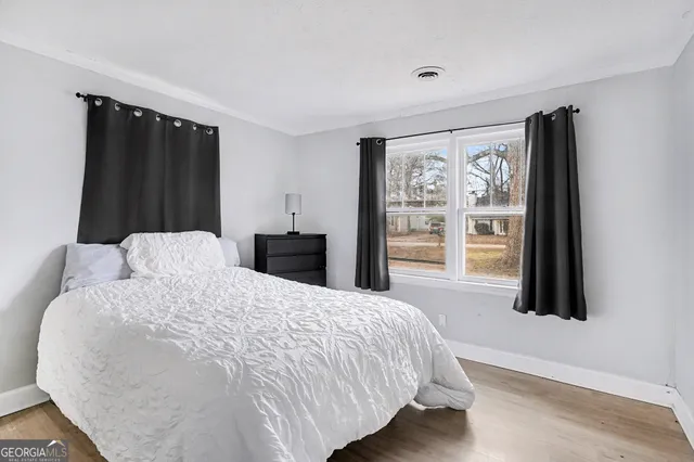 a large bed sitting in a bedroom next to a window