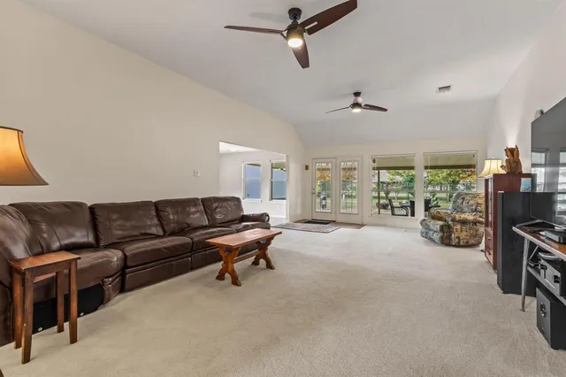 a living room with furniture and a ceiling fan