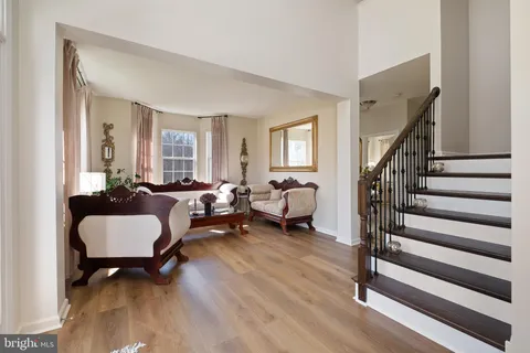 a view of a hallway with wooden floor and a livingroom