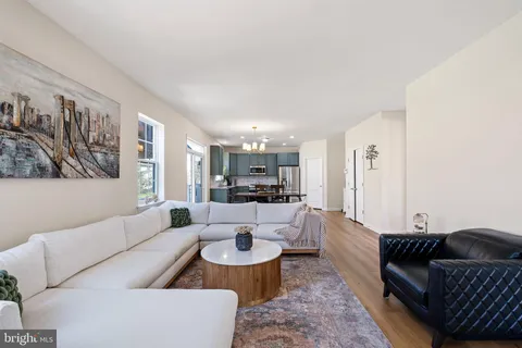 a living room with furniture and a view of kitchen