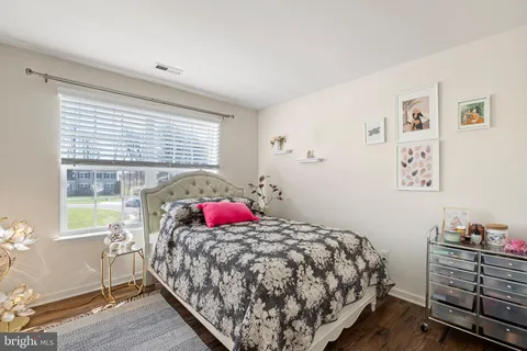 a bedroom with a bed and a lamp on dresser