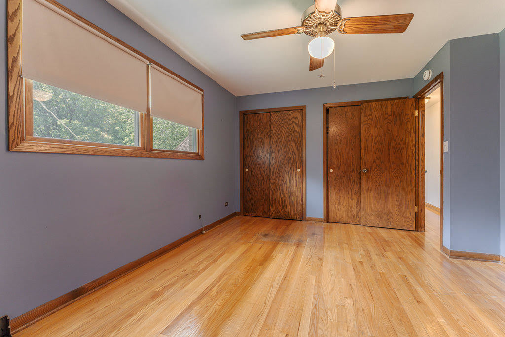 14322 McCarthy Road Lemont, IL 60439 - Photo 13 of 37 an empty room with wooden floor chandelier fan and windows