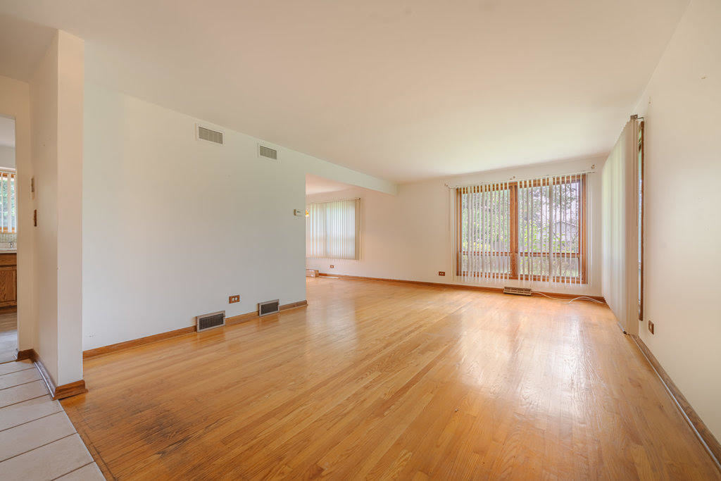 14322 McCarthy Road Lemont, IL 60439 - Photo 4 of 37 an empty room with wooden floor and windows