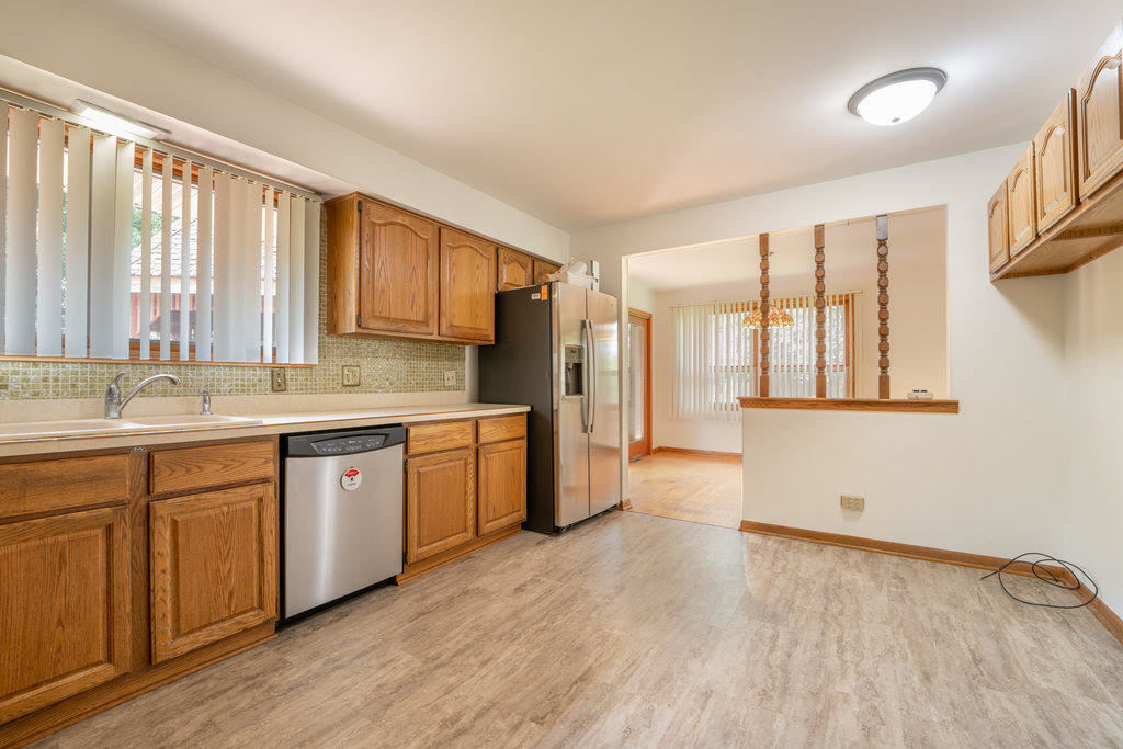 14322 McCarthy Road Lemont, IL 60439 - Photo 10 of 37 a kitchen with stainless steel appliances granite countertop a stove a sink dishwasher and a refrigerator with wooden floor