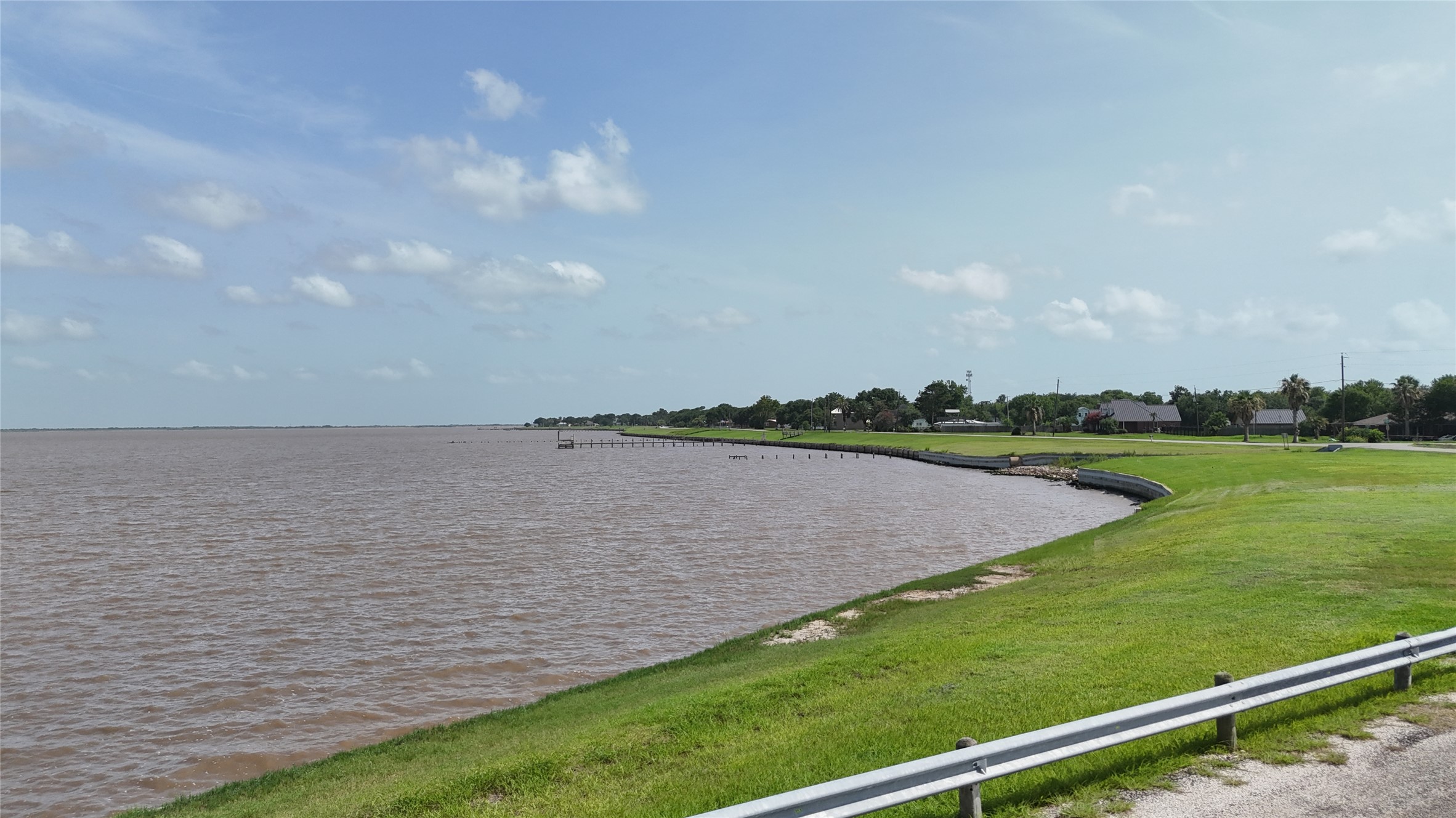 305 Bayshore Road Palacios, TX 77465 - Photo 24 of 25 Discover expansive waterfront views with lush green landscaping stretching along the shoreline.