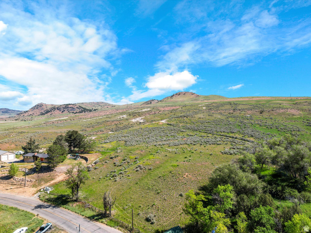 15610 North Beaver Dam Road, Unit 2 Collinston, UT 84306 - Photo 5 of 10 Expansive rural landscape featuring a single-story residence, mature trees, and mountainous terrain