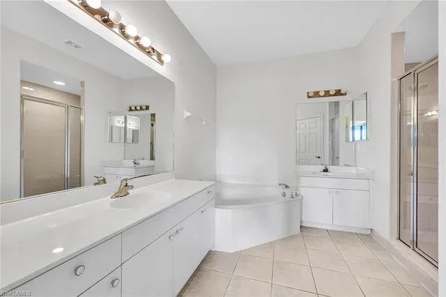 a bathroom with a bathtub shower sink and mirror