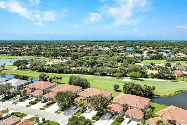 an aerial view of a houses with yard and green space