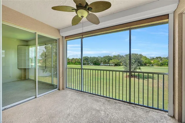 a view of a green field with trees in the background