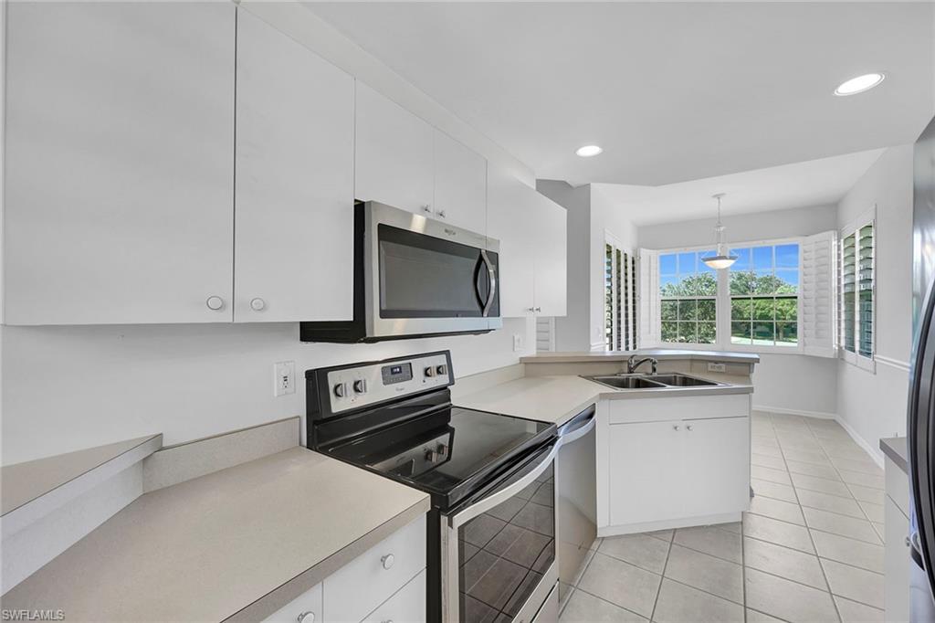 2015 Crestview Way, Unit 17B Naples, FL 34119 - Photo 8 of 29 a kitchen with a stove a sink and a microwave
