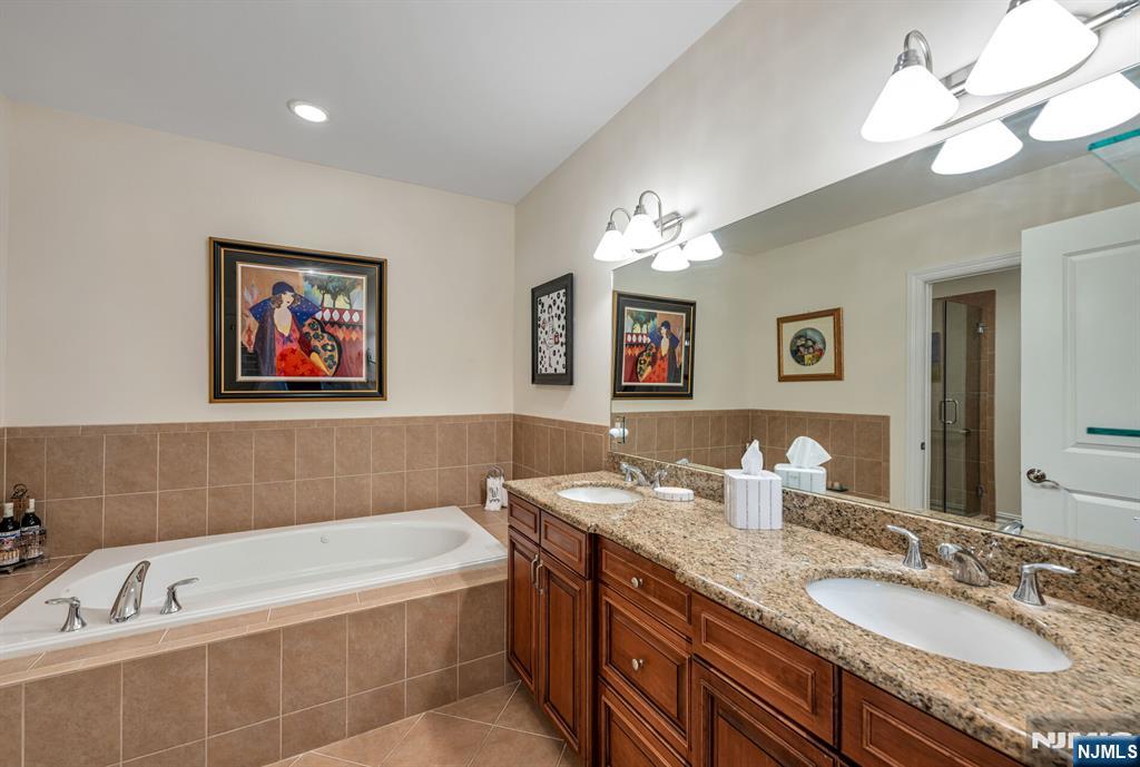 2310 Rio Vista Lane, Unit 2310 Northvale, NJ 07647 - Photo 21 of 49 a bathroom with a granite countertop tub a double vanity sink and a mirror