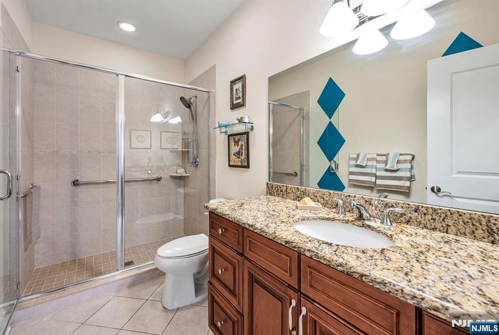2310 Rio Vista Lane, Unit 2310 Northvale, NJ 07647 - Photo 27 of 49 a bathroom with a granite countertop sink toilet a mirror and shower