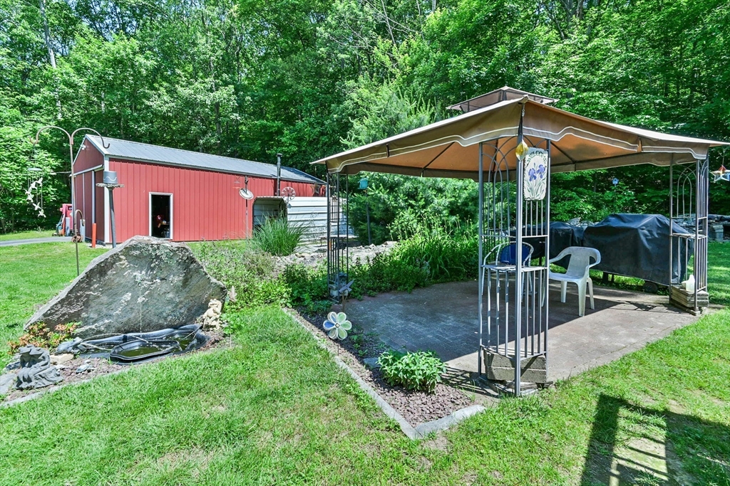 161 Gore Road Webster, MA 01570 - Photo 9 of 42 a backyard of a house with table and chairs under an umbrella